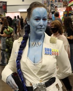 a cosplayer with blue skin poses for a photo