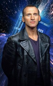 Eccleston poses in front of Dr. Who poster