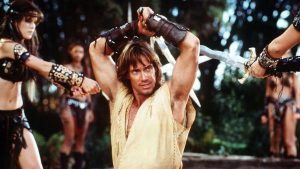 Actor Kevin Sorbo as Hercules tied up and held prisoner by female warriors.