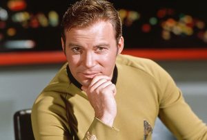 Captain James T. Kirk stares at the universe from his chair on the bridge