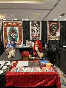 woman sitting in a tattoo booth with anime tattoo books